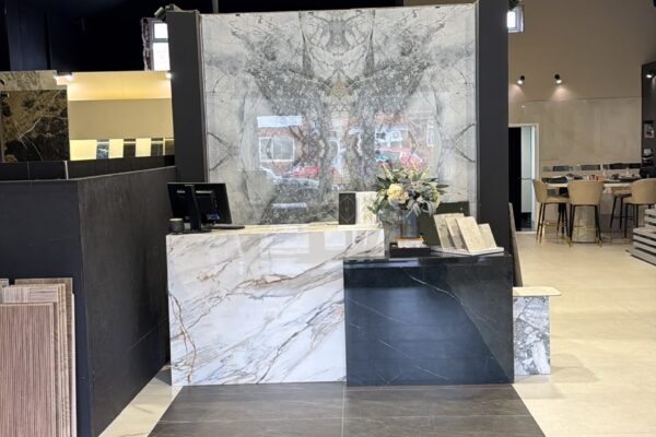 Showroom interior with marble countertops, sample boards, and a reception desk in foreground.
